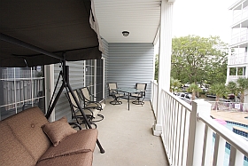 Sky Blue Vacation Condo, Myrtle Beach - Lower Balcony with three person swing, table, four chairs